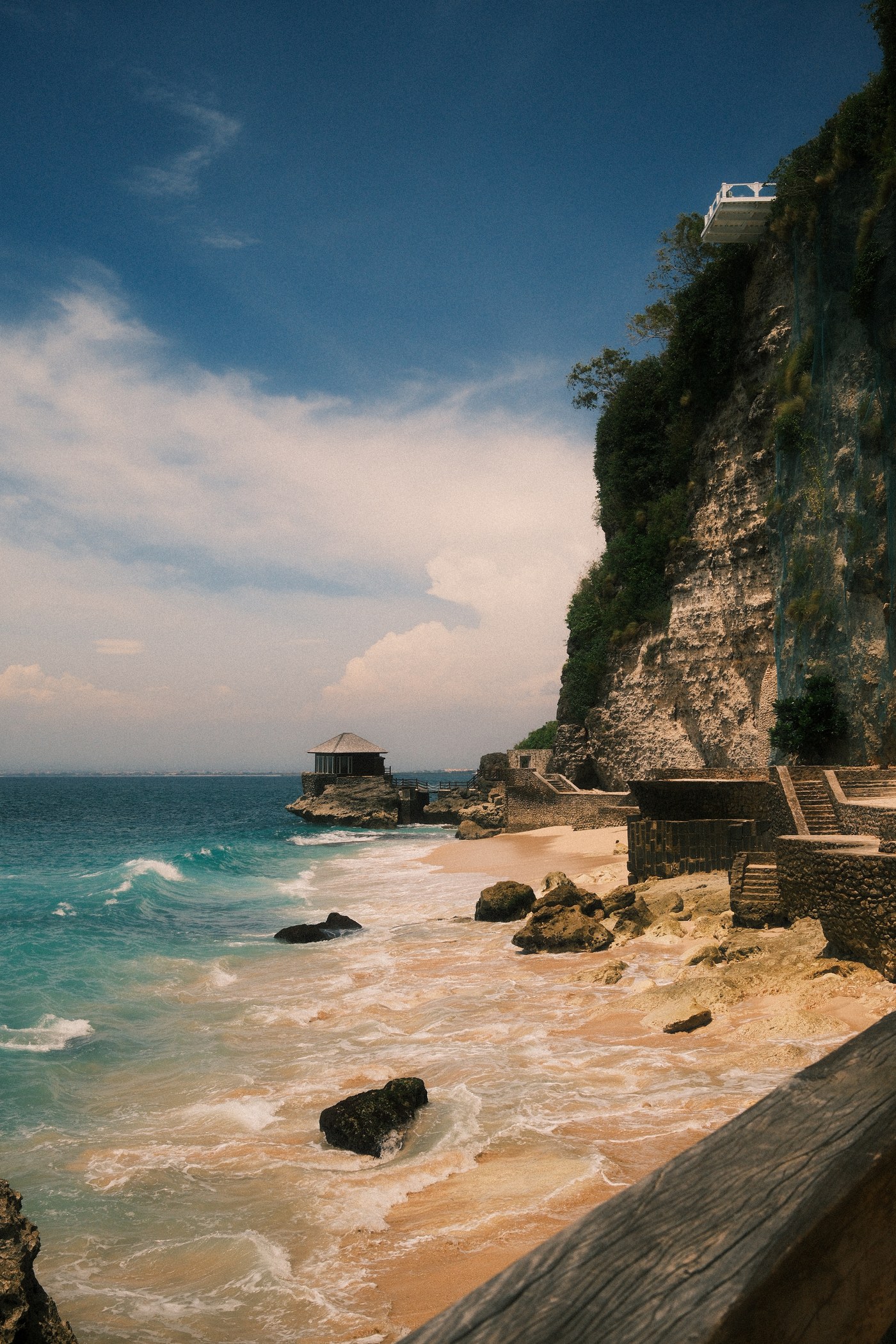 Turquoise water below a warm cliff